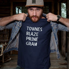 Man wearing a navy blue t-shirt with text in a rustic setting