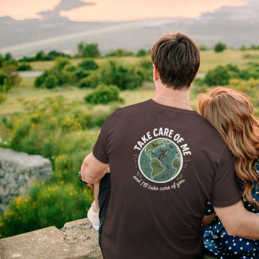 Man wearing Take Care of Me t-shirt back view Earth planet graphic
